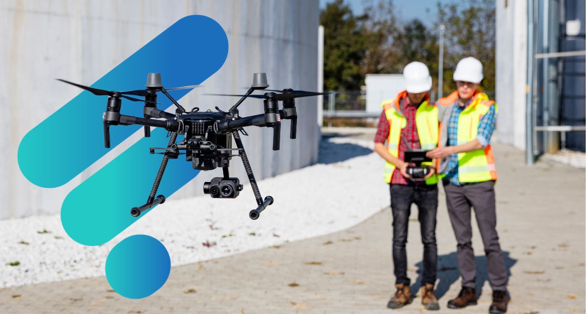 two construction workers in yellow vests operating a drone